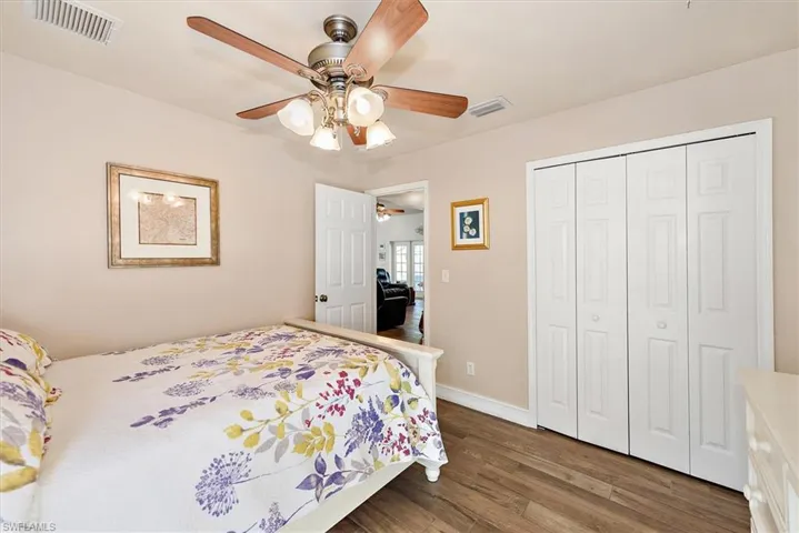 Bedroom with dark wood-type flooring, a closet, and ceiling fan