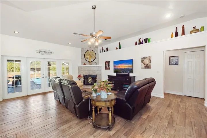 Living area featuring recessed lighting, light wood-style floors, a tile fireplace, french doors, and ceiling fan