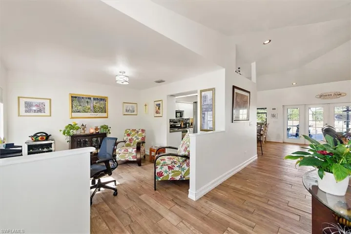 Office space featuring lofted ceiling, light wood-style flooring, and recessed lighting