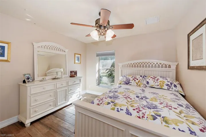 Bedroom with dark wood-style flooring and a ceiling fan