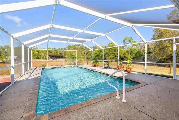 Swimming pool with a lanai, a sunroom, and a patio area