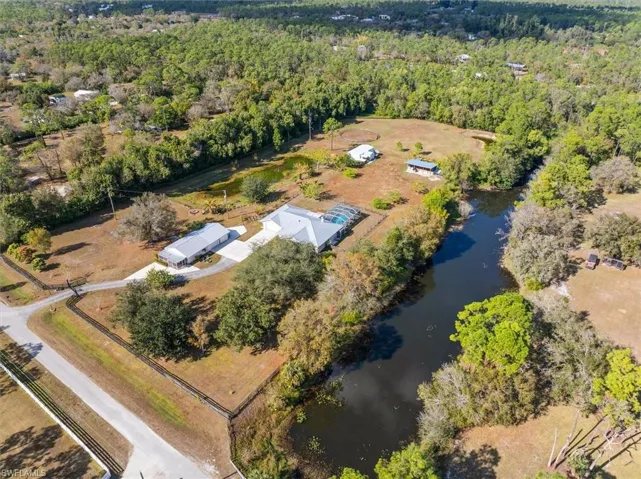Aerial view of property's location featuring a large body of water and a heavily wooded area