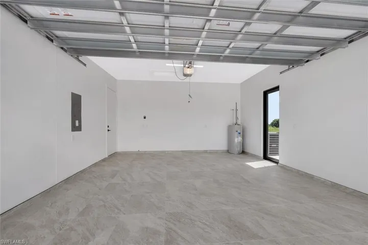 Garage featuring electric panel and water heater