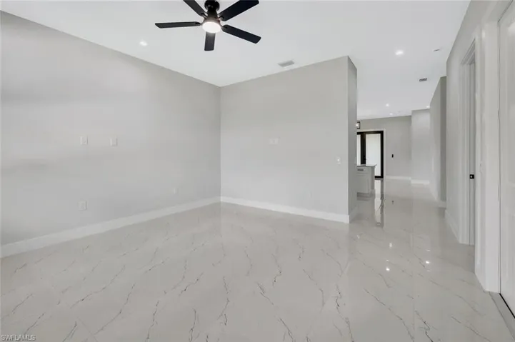 Empty room with recessed lighting, light marble finish floors, and a ceiling fan