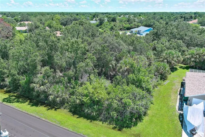 Aerial view of property and surrounding area featuring a heavily wooded area