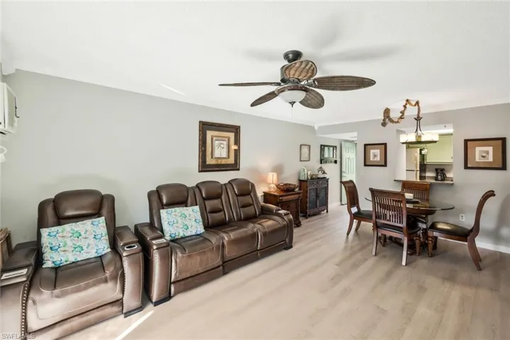 Living room with ornamental molding, light wood-style floors, and a ceiling fan
