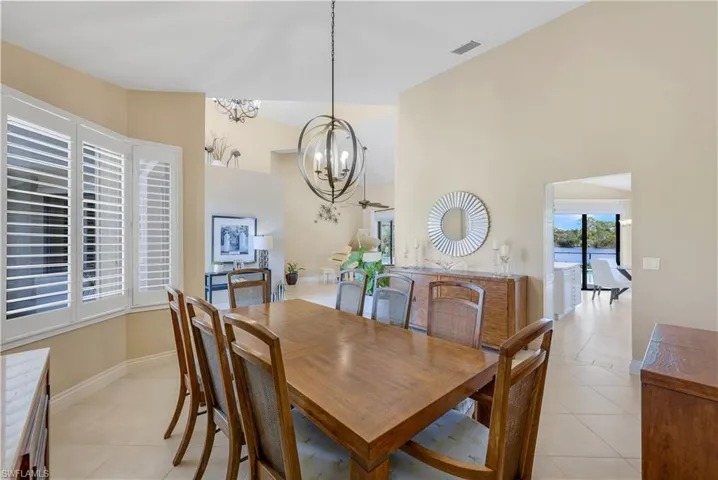 Dining room with light tile patterned flooring and a notable chandelier