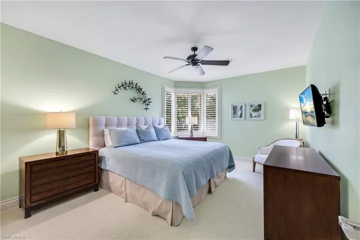 Carpeted bedroom featuring ceiling fan