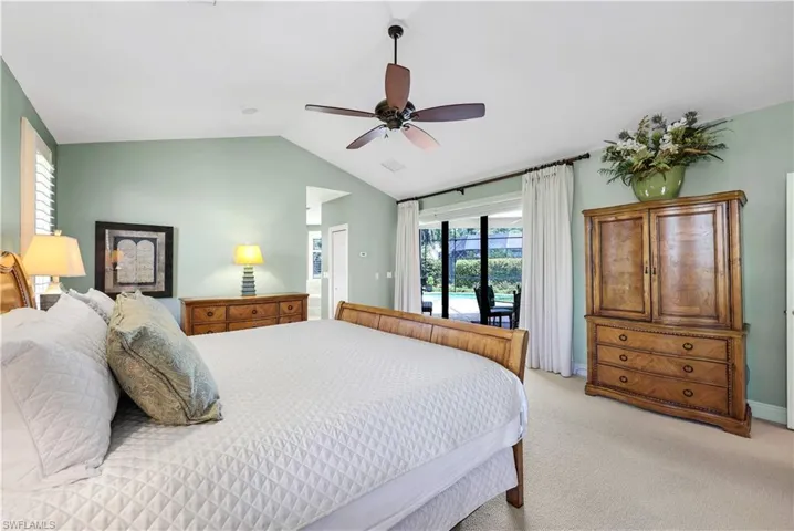 Bedroom with light carpet, vaulted ceiling, ceiling fan, and access to exterior