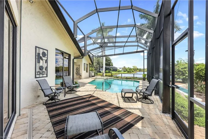 View of swimming pool featuring a patio and a lanai