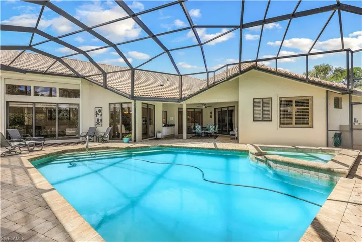 View of swimming pool featuring an in ground hot tub, a lanai, and a patio area