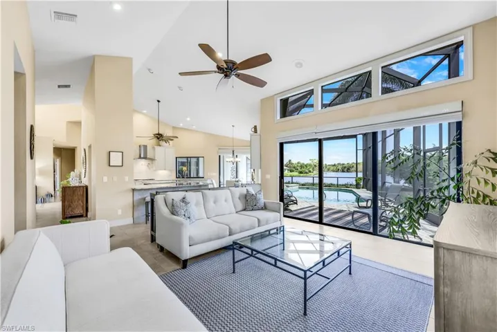 Tiled living room with high vaulted ceiling and ceiling fan