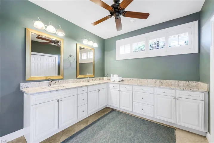 Bathroom with tile patterned flooring, ceiling fan, and vanity