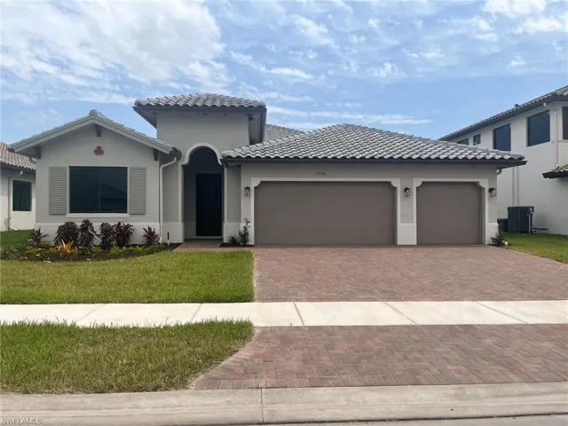 Mediterranean / spanish house with a garage, a front yard, and central air condition unit