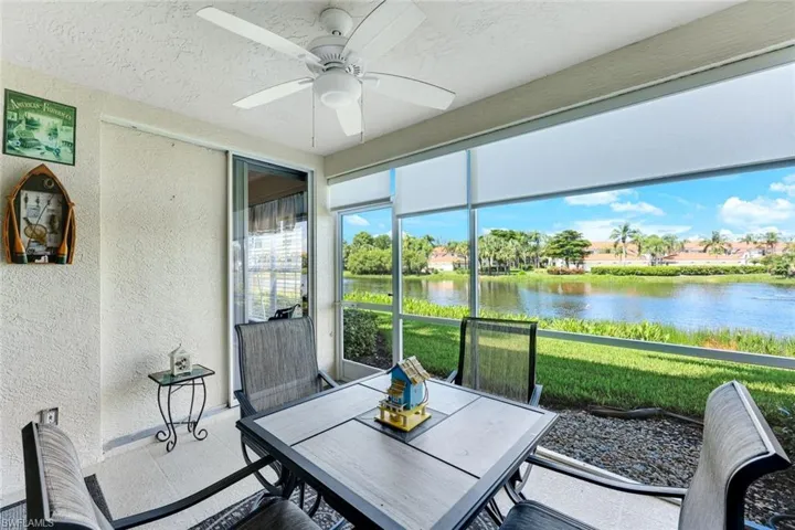 Sunroom / solarium with a ceiling fan, a water view, and outdoor dining area