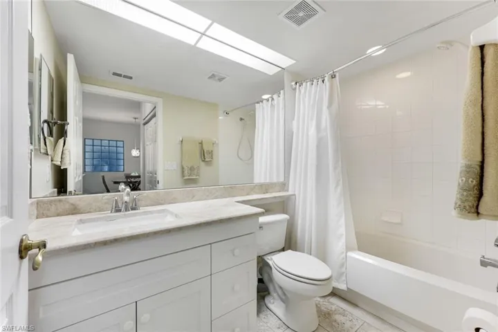 Full bathroom with vanity, shower / tub combo with curtain, and tile patterned flooring