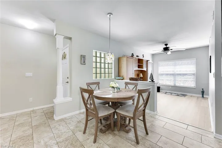 Dining room featuring ornate columns, a ceiling fan, and light tile patterned floors