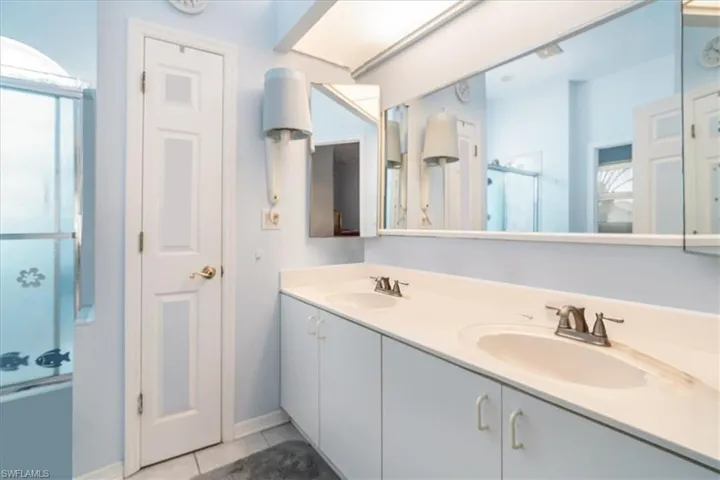 Bathroom with vanity, an enclosed shower, and tile patterned floors