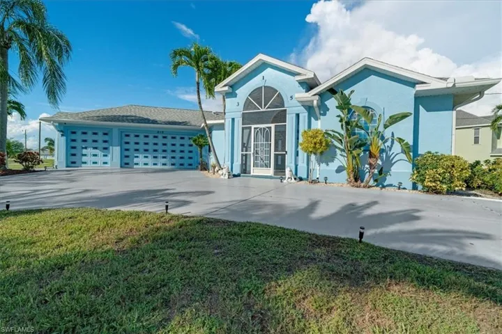 View of front facade featuring a garage and a front lawn