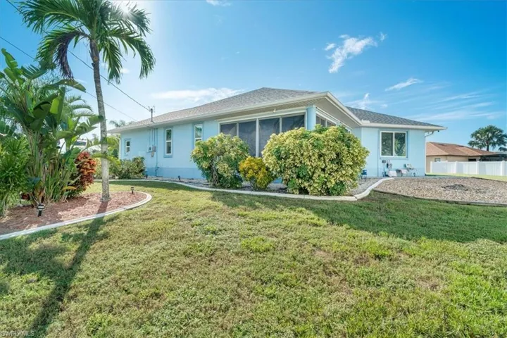 View of side of home featuring a yard and a sunroom