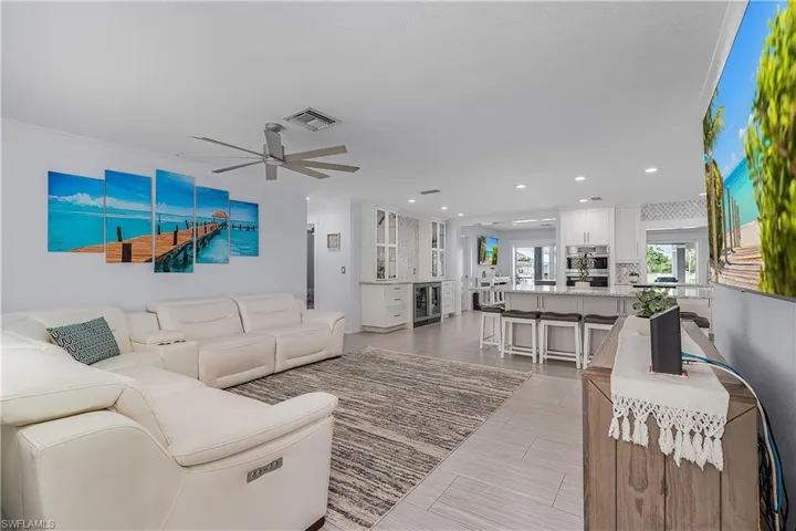Living area featuring visible vents, recessed lighting, ceiling fan, and wine cooler