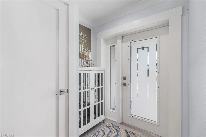 Foyer entrance featuring wood finished floors and crown molding