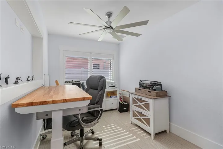 Office space with baseboards and a ceiling fan