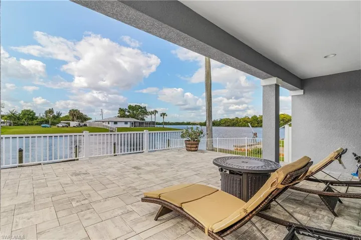 View of patio featuring fence and a water view