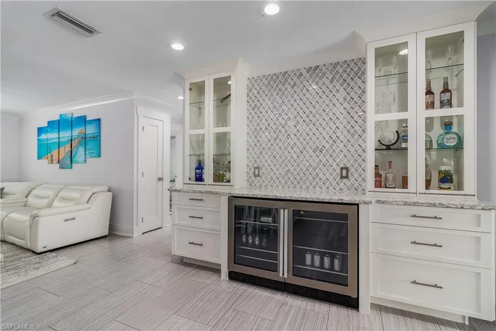Bar featuring visible vents, a dry bar, recessed lighting, wine cooler, and backsplash