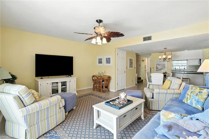 Tiled living room with a chandelier and ceiling fan - Virtually Edited Image