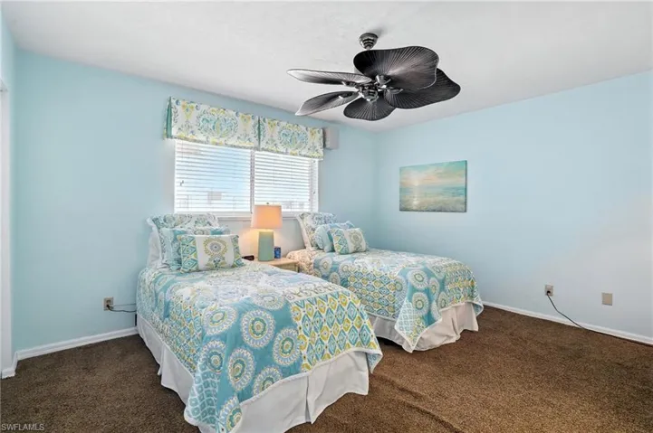 Carpeted bedroom with baseboards and a ceiling fan - Virtually Edited Image