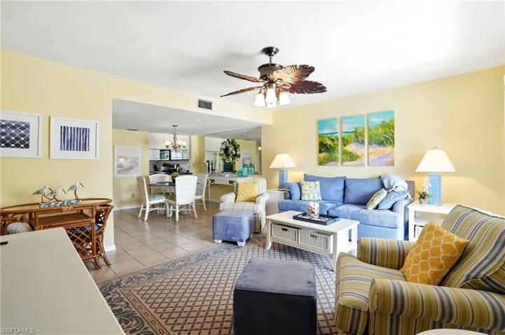 Tiled living room featuring ceiling fan and a chandelier - Virtually Edited Image
