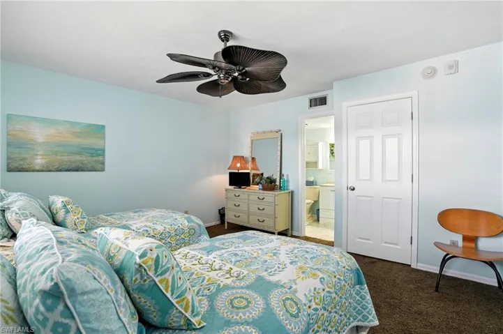 Carpeted bedroom with ensuite bathroom and a ceiling fan - Virtually Edited Image