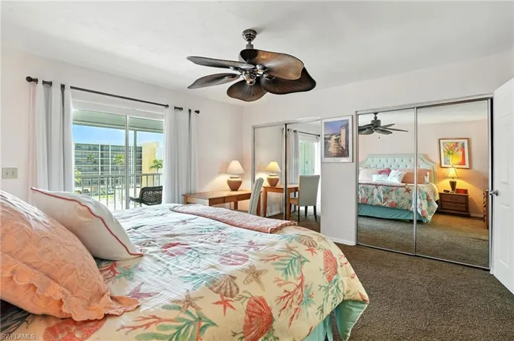 Bedroom with access to exterior, multiple closets, carpet floors, and a ceiling fan - Virtually Edited Image