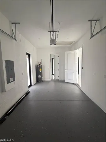 Spacious garage featuring a durable epoxy floor finish, white painted walls, and an automatic garage door opener system