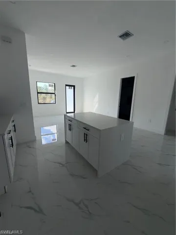 Central kitchen island with white cabinetry and a light-toned countertop