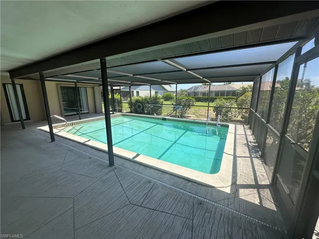 Outdoor pool featuring glass enclosure and a patio area