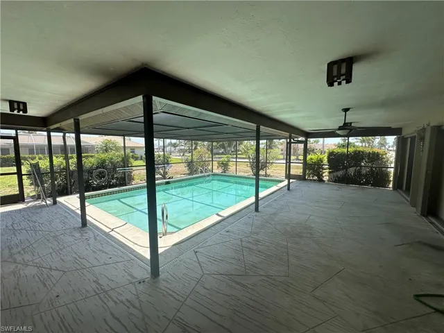 Outdoor pool featuring a patio and glass enclosure
