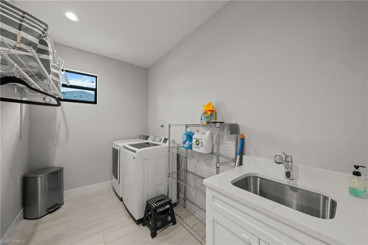 Laundry room with washer and clothes dryer and recessed lighting