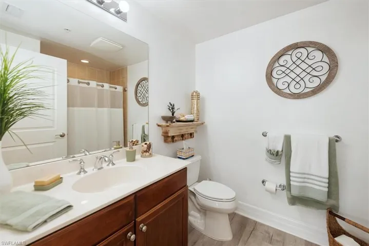 Full bathroom featuring vanity, a shower with curtain, and light wood-style flooring