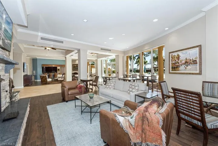 Living area with a fireplace, dark wood finished floors, crown molding, and recessed lighting
