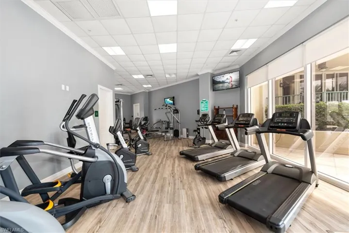Gym with ornamental molding and a paneled ceiling