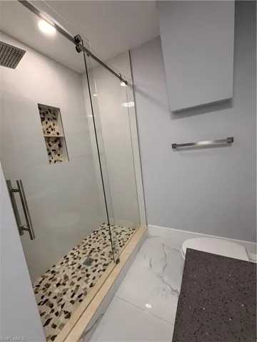 Bathroom 3 Master with a shower stall and marble look tiles