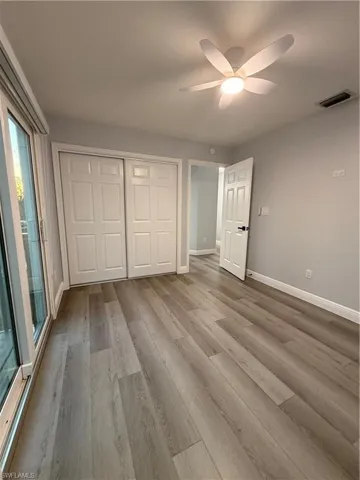 Unfurnished bedroom 1 with a closet, ceiling fan, and light wood-style floors