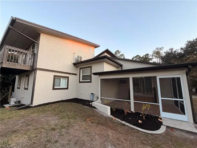 Back of house featuring stucco siding and a sunroom