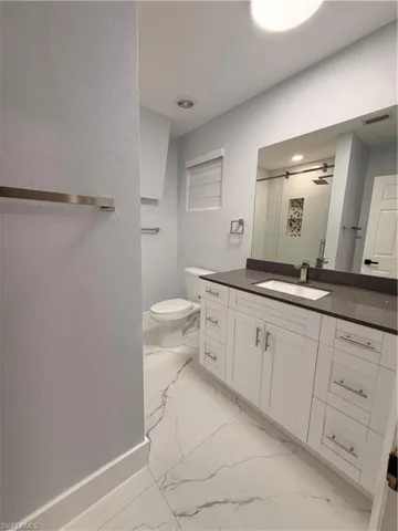 Bathroom 3 Master featuring vanity, a shower stall, a textured wall, and light marble finish flooring
