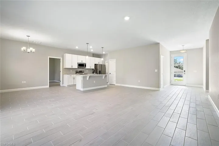Unfurnished living room with sink and an inviting chandelier