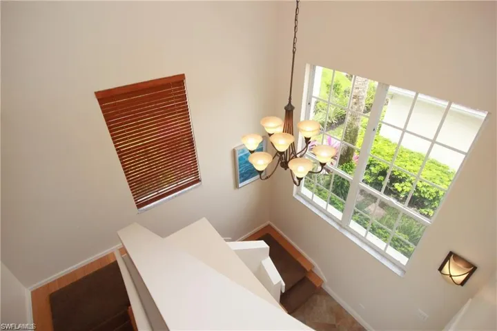 Stairway with a healthy amount of sunlight and a high ceiling