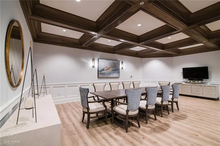 Dining area featuring light wood-type flooring, crown molding, coffered ceiling, and beamed ceiling
