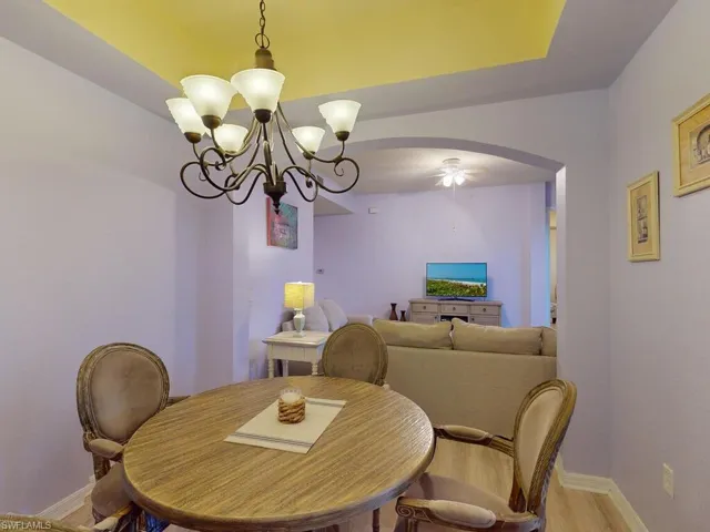 Dining room with ceiling fan with notable chandelier and wood-type flooring